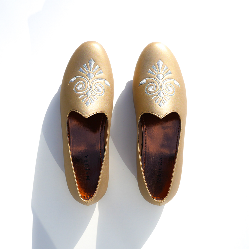Birds eye view of Gold leather Mojris with a rose gold insole branded with the Majora Logo